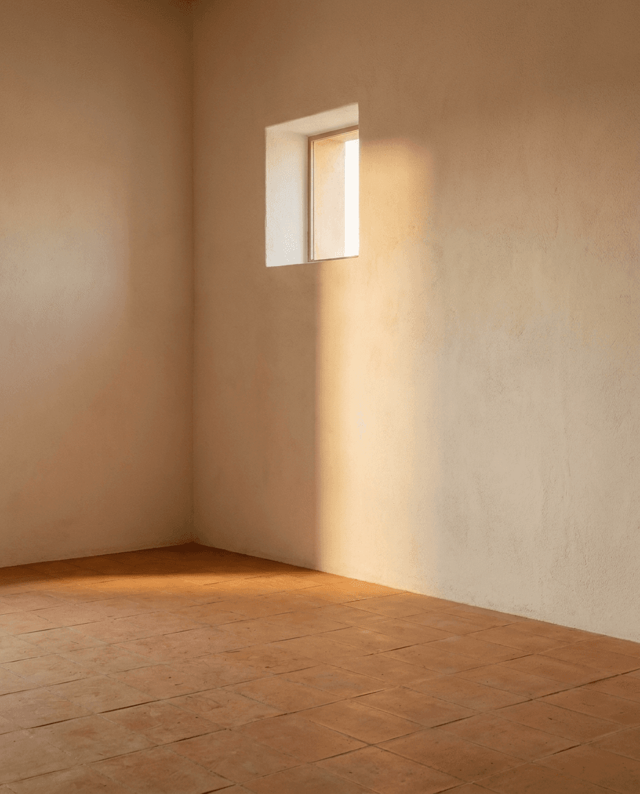 Couloir minimaliste baigné de lumière naturelle, mur de pierre claire